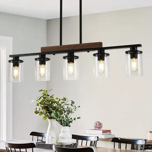 CmnVmn 5-light black linear pendant light with clear glass shades over a kitchen table