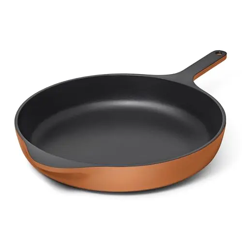 Caraway enameled cast iron skillet in rust color on glass top stove